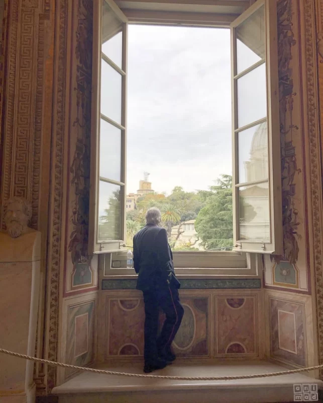 Photo of a Solitary museum guard lost in his  thought by a large window. Travel Art Stories from the Vatican Museum's Gallery of Tapestries - ANIMaD