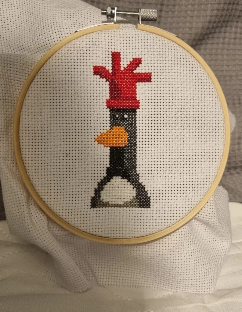 Cross-Stitching image of a rooster that looks like a physical manifestation of Pixel Art. From Analog to Digital and Vice Versa, found on blue sky